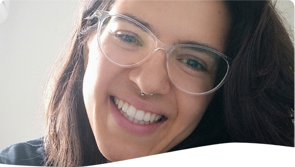 Girl with brown hair and using glasses smilling to the camera