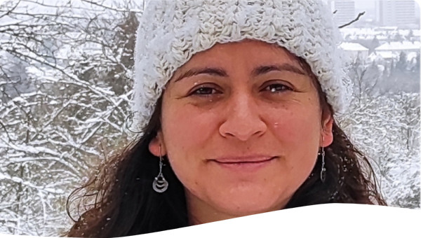 Shows a woman wearing a hat in the snow