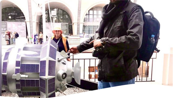 Indraneel Kulkarni pointing to a model satellite in Moscow