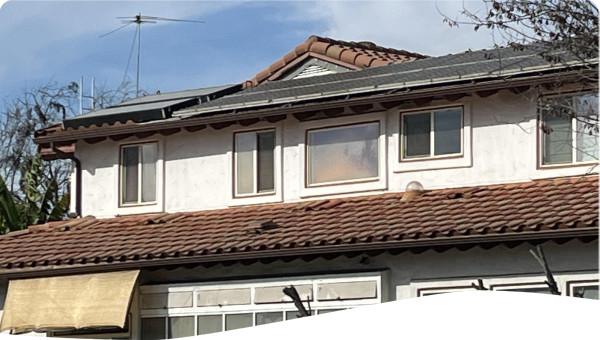 The photo illustrates the south elevation of the Arcadia Ecohome, with solar PV and water heater systems on the higher roof and passive solar energy installations at ground floor of the Ecohome.   